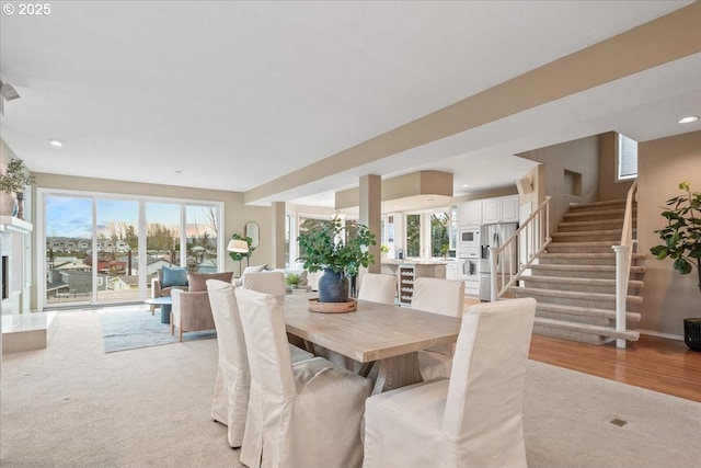 dining area featuring stairs, recessed lighting, light wood-style floors, and baseboards