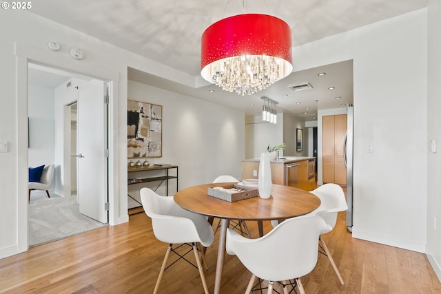 dining space featuring a notable chandelier, light wood-style floors, recessed lighting, baseboards, and visible vents