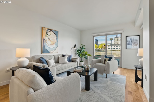 living area with baseboards and light wood finished floors
