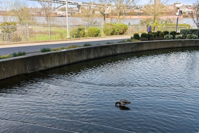 dock area with a water view and fence