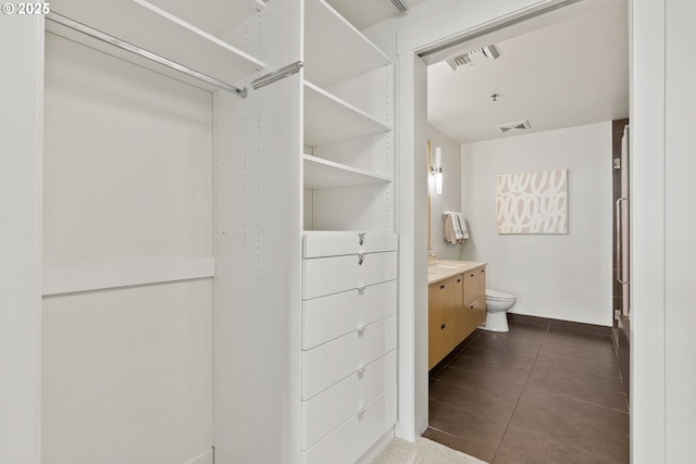 walk in closet with visible vents and dark tile patterned flooring