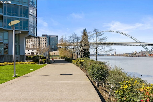 view of home's community with a lawn and a water view