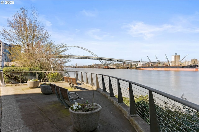 view of patio with a water view and a balcony