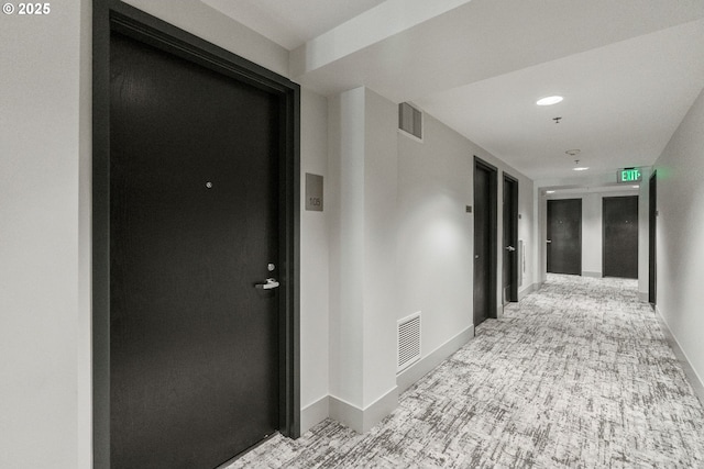 hall featuring baseboards, carpet flooring, and visible vents