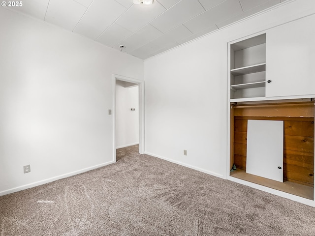 unfurnished bedroom with carpet flooring and baseboards