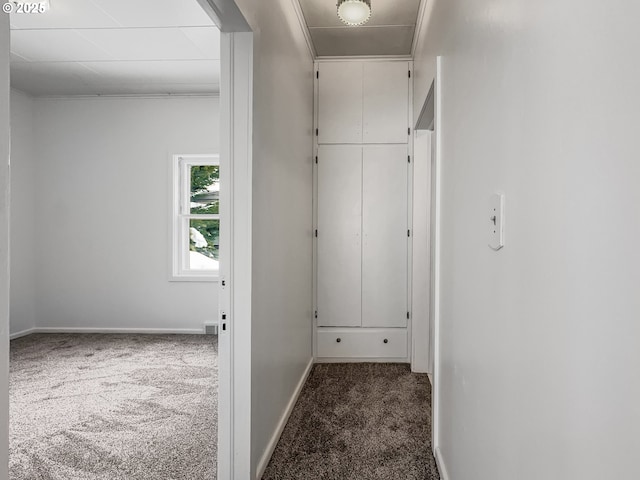 hallway with carpet floors and baseboards