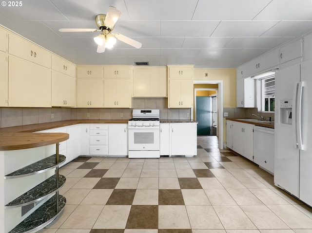 kitchen featuring white appliances, ceiling fan, visible vents, and decorative backsplash