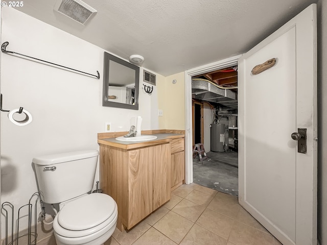 bathroom featuring visible vents, toilet, a textured ceiling, vanity, and water heater