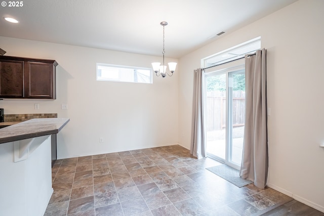 1067 S 55th St, Springfield, OR 97478 - unfurnished dining area featuring a chandelier and stone finish floors