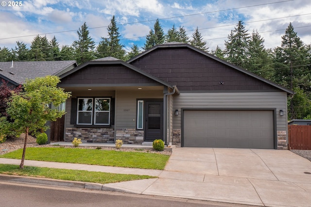 1067 S 55th St, Springfield, OR 97478 - view of front of property featuring concrete driveway, stone siding, an attached garage, and a porch