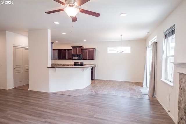 1067 S 55th St, Springfield, OR 97478 - kitchen with black microwave, a peninsula, dark brown cabinets, hanging light fixtures, and recessed lighting