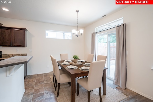 1067 S 55th St, Springfield, OR 97478 - dining room featuring a chandelier and dark stone finish floors