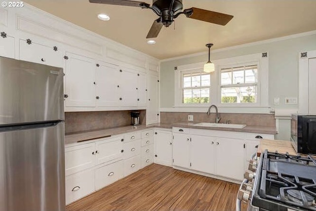 709 S Meridian St, Newberg, OR 97132 - kitchen featuring appliances with stainless steel finishes, ornamental molding, decorative backsplash, white cabinets, and light countertops
