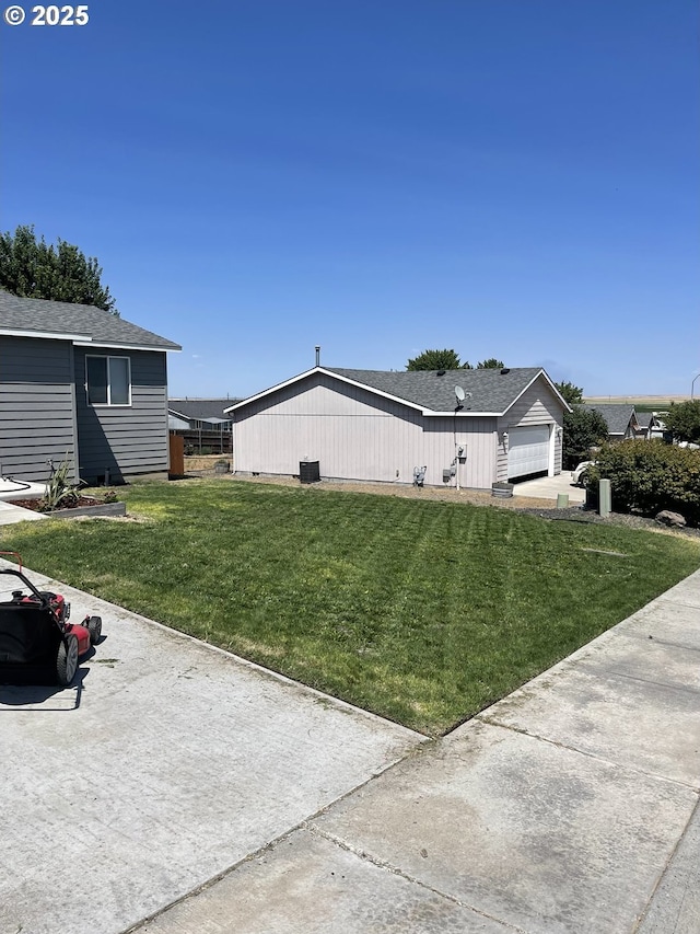 view of side of home with a garage and a lawn