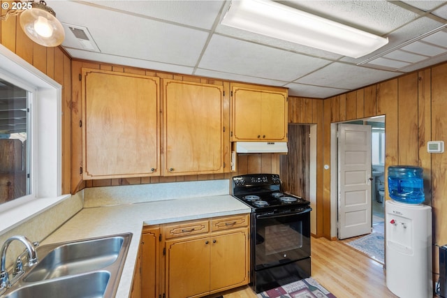 380 3rd Ave, Powers, OR 97466 - kitchen featuring black range with electric cooktop, under cabinet range hood, a sink, light countertops, and wood walls