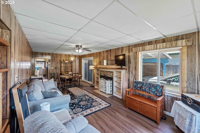 380 3rd Ave, Powers, OR 97466 - living room featuring wood walls, ceiling fan, a drop ceiling, and wood finished floors