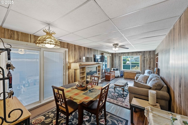 380 3rd Ave, Powers, OR 97466 - dining space featuring wooden walls, wood finished floors, a ceiling fan, and a paneled ceiling
