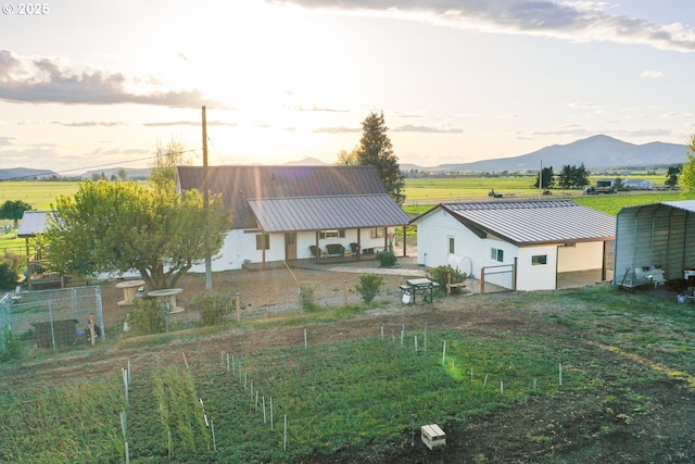 4664 N Mckay Rd, Prineville, OR 97754 - back of property at dusk with metal roof, fence, and stucco siding