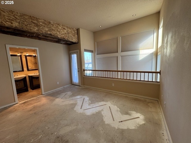 unfurnished bedroom with connected bathroom and a textured ceiling