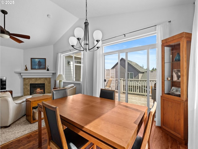 37149 Emerald Cascade, Sandy, OR 97055 - dining room with lofted ceiling, wood finished floors, a tiled fireplace, a chandelier, and ceiling fan