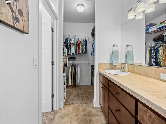 37149 Emerald Cascade, Sandy, OR 97055 - full bath with vanity, a walk in closet, and a textured ceiling