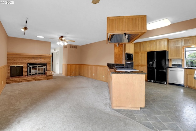 kitchen featuring built in microwave, a wainscoted wall, dishwasher, and black fridge