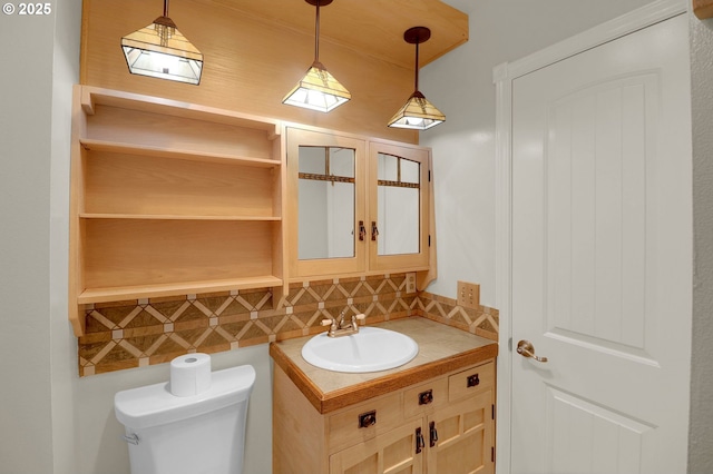 bathroom with decorative backsplash, toilet, vanity, and french doors