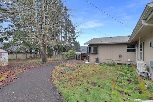 view of yard with ac unit and fence