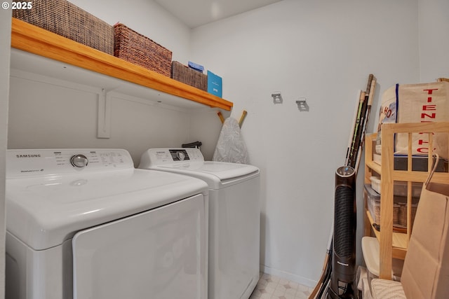 laundry area featuring independent washer and dryer, light floors, and baseboards