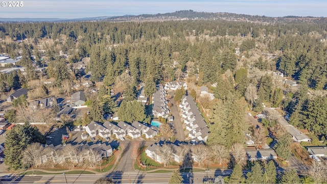 aerial view of property and surrounding area with a heavily wooded area