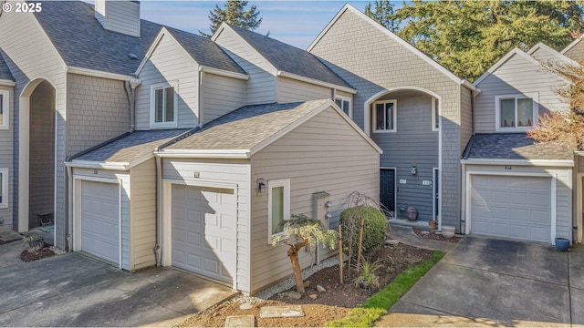 traditional-style home featuring a shingled roof and a garage