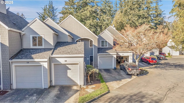 traditional-style home with driveway, a shingled roof, and an attached garage