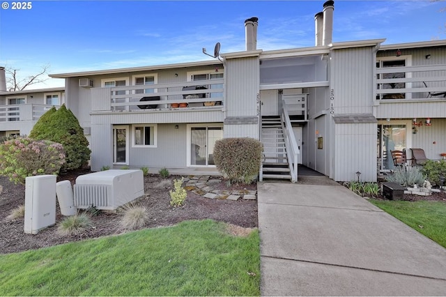 exterior space with stairway and a wall mounted air conditioner