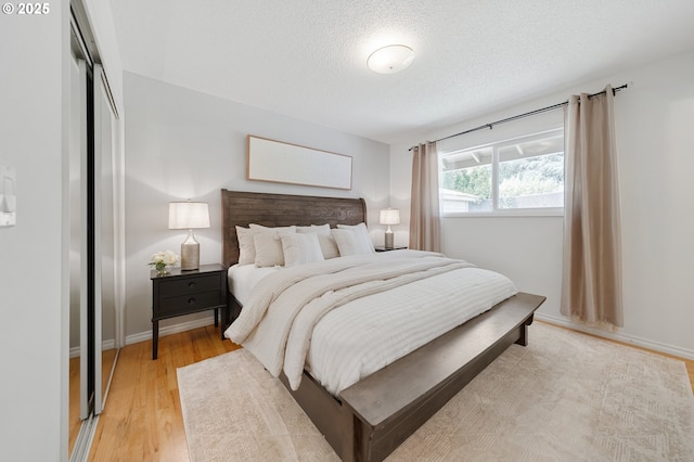 13440 SW Greenleaf Pl, Beaverton, OR 97005 - bedroom featuring light wood finished floors, a textured ceiling, and a closet
