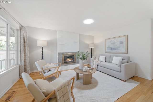 13440 SW Greenleaf Pl, Beaverton, OR 97005 - living area featuring light wood finished floors, baseboards, and a fireplace