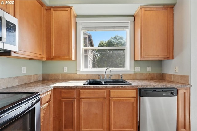 kitchen with stainless steel appliances, a sink, and light countertops