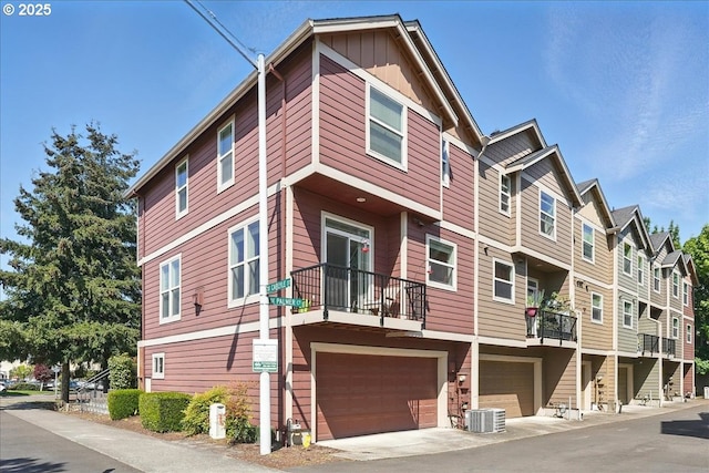 view of building exterior featuring a garage, central AC unit, and a residential view