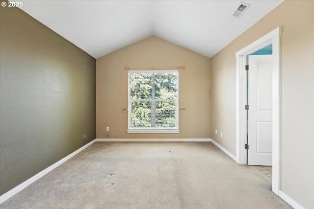 empty room with vaulted ceiling, carpet flooring, and baseboards