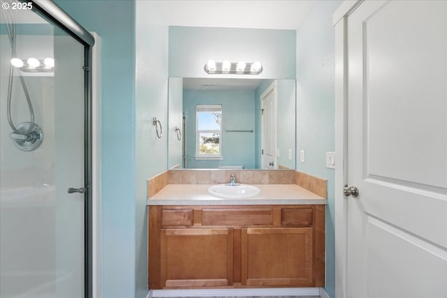 full bath featuring a shower with shower door and vanity