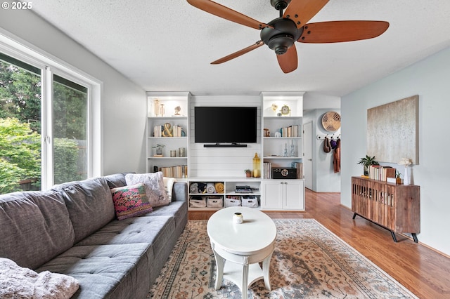 living area with ceiling fan and light wood finished floors