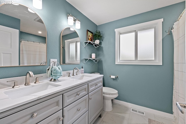 bathroom with a sink, plenty of natural light, and visible vents