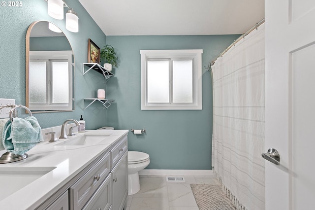 bathroom featuring visible vents, a sink, plenty of natural light, and toilet