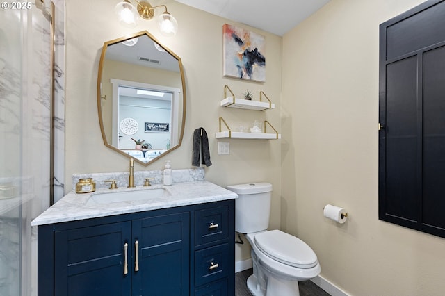 bathroom featuring toilet, baseboards, visible vents, and vanity
