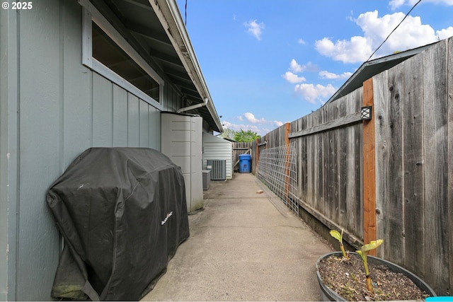 view of property exterior with central AC and fence