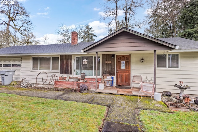 ranch-style home with a shingled roof, a chimney, and a front yard