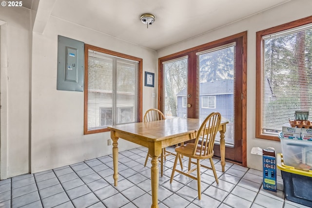 dining space with electric panel, a wealth of natural light, and light tile patterned flooring