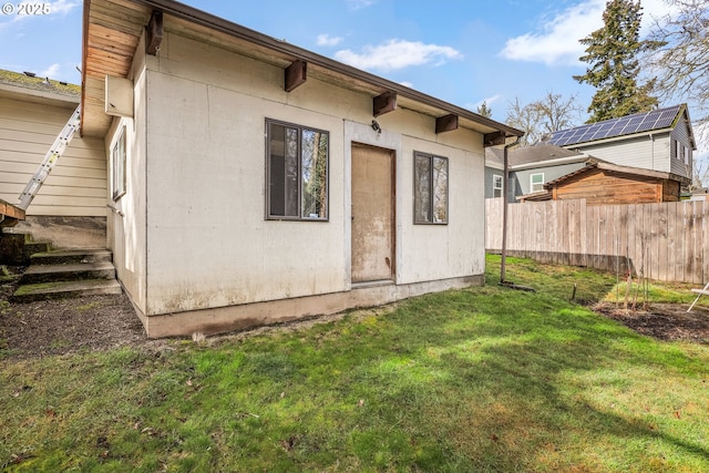 back of house with fence and a yard