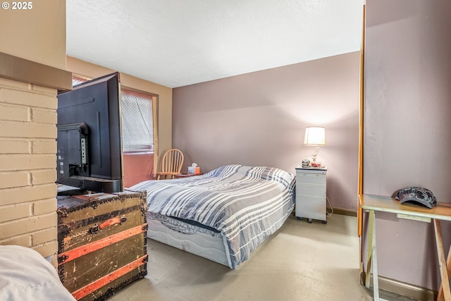 bedroom featuring concrete floors and baseboards