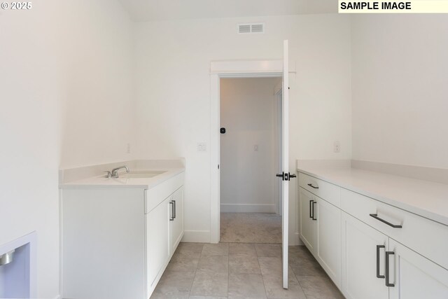 bathroom with tile patterned floors and vanity