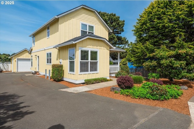 1537 NW 21st St, Lincoln City, OR 97367 - view of property exterior featuring board and batten siding, an outdoor structure, and asphalt driveway